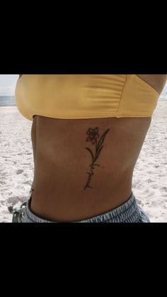 a woman with a flower tattoo on her lower back and the bottom part of her stomach