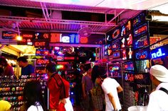 several people are standing in front of a store with neon signs on the walls and ceiling