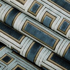 several blue and beige rugs stacked on top of each other