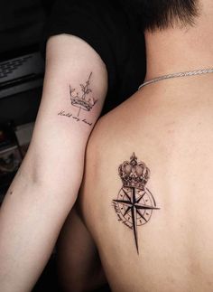 two people with tattoos on their backs, one has a compass and the other has a crown