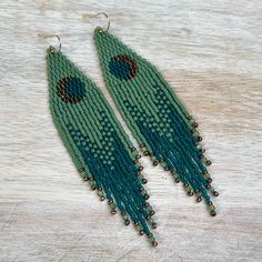 Full moon beaded earrings in green shades, accented with green apatite gemstone beads at the fringe ends. Ultra lightweight!  Details~ * Made with lightweight, glass, Delica seed beads and sterling silver ear wires.  * Length: Drop length (including ear wire) is 10 1/2 cm. Width is 2 cm.   * Packaging: Your order will arrive lovingly packaged in a gift box, wrapped with a ribbon and ready for gifting. * Please visit my Etsy shop for a full selection of my handmade jewelry: https://www.etsy.com/s Cheap Green Beaded Earrings, Green Chandelier Earrings With Dangling Beads For Festivals, Green Bohemian Teardrop Chandelier Earrings, Bohemian Green Teardrop Chandelier Earrings, Green Beaded Earrings For Festival, Handmade Green Tassel Earrings For Festival, Green Tassel Earrings With Fringe For Festivals, Adjustable Green Chandelier Earrings With Dangling Beads, Green Dangle Chandelier Earrings With Latkans