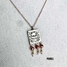 This exquisite Joyeria Plata necklace, featuring a unique Papel Picado pendant, is a masterpiece of Mexican craftsmanship. Handcrafted with meticulous attention to detail, it echoes the rich cultural heritage of Artesanias Mexicanas. The delicate Papel Picado design, a traditional Mexican folk art, is beautifully rendered in silver, making this Taxco necklace a captivating piece of Joyeria Mexicana. Adorned with intricate patterns, it captures the vibrant spirit of celebrations like Cinco de Mayo and Dia de los Muertos. This Mexican silver necklace is more than just an accessory; it's a symbol of Mexican tradition and artistry. With its fine craftsmanship and unique design, it stands out as a stunning representation of Taxco's renowned silverwork. The Papel Picado pendant adds a touch of e Artisan Silver Necklace With Rectangular Pendant, Handmade Silver Necklace With Rectangular Pendant, Artisan Silver Etched Necklace, Festive Silver Necklace With Pearl Pendant, Ornate Silver Necklace With Pearl Pendant, Copper Beaded Pendant Jewelry, Beaded Copper Pendant Jewelry, Sterling Silver Dangle Necklace For Festivals, Silver Brass Jewelry With Rectangular Pendant