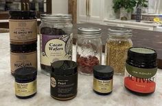 jars filled with different types of spices sitting on a counter