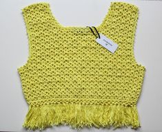 Crochet yellow crop top with tassels festival beach style Available in UK 12 to buy now. See below on how to preorder if you would like a different size: We're a UK brand that specialise in handmade clothing. All our items are created by Anne Lee, with help from Amy. Our styles reflect hippie/bohemian fashion and we like to mix bright colours and patterns to create one of a kind items.  Every item is slightly different and unique, all handmade personally for you with love. This means we only sell in limited quantities and not every size/style is listed. If you are interested in an item and would like to pre-order this in your size, please send us a message. Please check out our other items x Trendy Tasseled Tops For Festivals, Sleeveless Fringe Top For Beach Season, Casual Crochet Top With Tassels For Vacation, Sleeveless Tassel Crop Top For Summer, Spring Festival Sleeveless Crop Top, Yellow Crochet Crop Top For Summer, Yellow Bohemian Crochet Top For Festival, Beach Crop Top With Fringe Detail, Spring Beachwear Cropped Crop Top