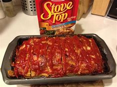 a pan filled with meat covered in sauce next to a box of stove top chicken