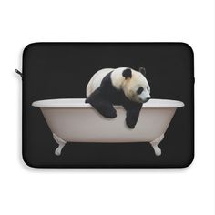 a black and white panda bear sitting in a bathtub