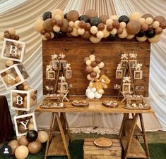 a wooden table topped with balloons and pictures