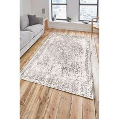 a living room area with hardwood floors and white rugs on the wooden flooring