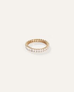 a gold ring with three rows of white stones on the inside and outside of it