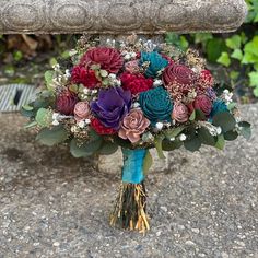 a bridal bouquet sitting on top of a stone bench