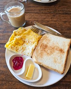 a plate with toast, eggs and butter on it next to a cup of coffee