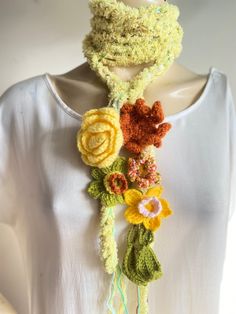 a crocheted scarf with flowers attached to it