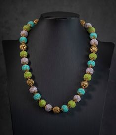 a necklace with multicolored beads on a mannequin