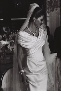 black and white photograph of a woman in a wedding dress with veil over her head