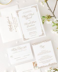 the wedding stationery is laid out on top of each other, with flowers and greenery