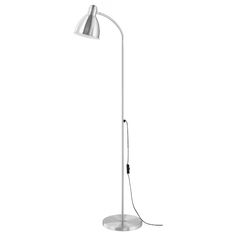 a white floor lamp with a black cord on the end and a silver shade over it