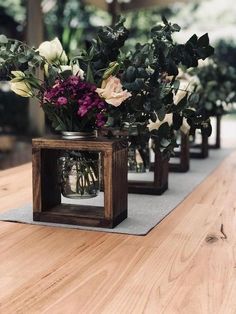 some flowers are sitting in glass vases on a table