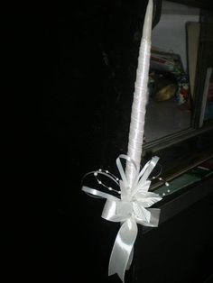 a white candle with a bow tied around it