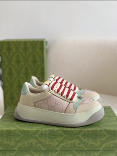 Embrace vintage-inspired style with a modern twist in these Gucci Screener-inspired sneakers. The beige upper, accented with subtle monogram detailing and pops of mint green and red, creates a fresh and playful look. The chunky sole and mixed material construction add retro athleticism, while the overall design exudes a sense of understated luxury. Perfect for those seeking a statement sneaker with a vintage vibe. Luxury Custom Beige Sneakers With Gum Sole, Luxury Green Custom Sneakers With Speckled Midsole, Luxury Green Custom Sneakers For Streetwear, Gucci Snake Sneakers, Gucci Screener, Understated Luxury, Bottega Veneta Shoulder Bag, Loafer Sneakers, Vintage Vibe