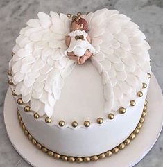 a white cake decorated with an angel on top