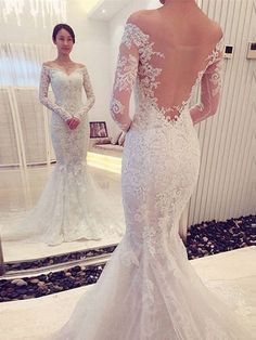 a woman in a wedding dress looking at herself in the mirror