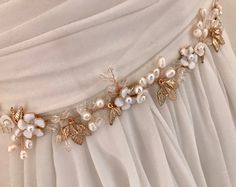 "Elegant Freshwater Pearl floral bridal sash for your most romantic day! This hand wired wedding belt combines soft white enamel flowers, tiny shell flowers Freshwater Pearls, crystal beads and small gold stamped leaves. It brings elegant style to botanical beauty and would be beautiful with many wedding themes. READY TO SHIP DETAILS * Measures aprox.1.5\" wide (at widest part) by 13\" long. * Attached at ends to imported French satin ribbon in choice of colors. * Total sash length 3 yards. * Of Elegant Bridal Belt With Flower Decoration, Elegant Bridal Belt With Flower Decoration For Wedding, White Bridal Belt With Sashes For Bridesmaid, White Bridal Sash Belt For Bridesmaid, Elegant Bridal Belt With Handmade Flowers For Weddings, Elegant Bridal Belt With Handmade Flowers, White Bridal Accessories With Sashes, Elegant White Sashes For Bridal Shower, Crystal Wedding Tiaras