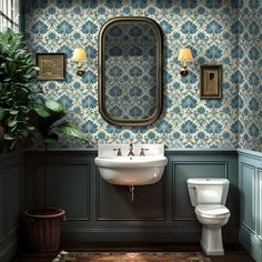 a bathroom with blue and white wallpaper, a toilet, sink and mirror in it