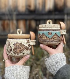 two handmade pottery pots with designs on them