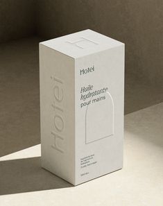 a white box sitting on top of a table next to a wall with the word hotel written on it