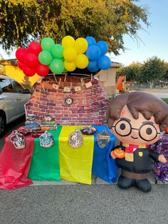 there is a fake harry potter with balloons on the table and other items in front of it