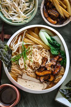 an overhead view of a bowl of ramen with vegetables and meats in it