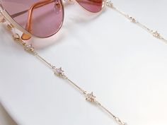 Dainty gold colour Zirconia star glasses chain, Delicate sunglasses chain, Travel essential gift for mother, Valentines Gift for her Lanyard 🌟length: approx 70cm 🌟they will be packaged into a reusable sealed bag. 🌟Glasses not included 🌟Shipment:  Standard (Free): untrackable Royal mail 2nd class (2-3 working days)  OR upgrade to 1st class/ trackable service when placing orders. :) ------------------------------------ ❤️For more necklaces https://www.etsy.com/uk/shop/LuluxStudio?section_id=40089585 ❤️For more rings https://www.etsy.com/uk/shop/LuluxStudio?section_id=40082442 ❤️For more Glasses Chains https://www.etsy.com/uk/shop/LuluxStudio?section_id=40995718 Trendy Star Charm Jewelry For Summer, Trendy Summer Jewelry With Star Charm, Trendy Summer Star-shaped Jewelry, Elegant Gold Glasses Chains With Delicate Chain, Elegant Gold Glasses Chain With Delicate Detail, Trendy Party Glasses Chains With Adjustable Chain, Summer Gold Jewelry With Star Charm, Trendy Adjustable Party Glasses Chains, Chic Adjustable Chain Glasses Chains For Party