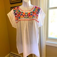 Nwot White Peasant Blouse W/Multi Color Embroidery. Size Medium Cotton No Size Or Fabric Tags, Purchased In Spain 21” From Armpit To Armpit Lying Flat 29” Long White Crew Neck Blouse With Embroidered Hem, White Blouse With Embroidered Hem And Crew Neck, White Short Sleeve Peasant Blouse, White Peasant Blouse With Short Sleeves, White Folk Style Peasant Top For Vacation, White Folk Peasant Top For Vacation, White Peasant Embroidered Top With Embroidered Border, White Casual Peasant Top With Embroidered Sleeves, White Peasant Top With Floral Embroidery