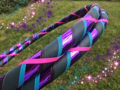 there is a purple and blue ribbon on the end of a hose in the grass