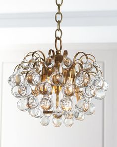 a chandelier hanging from the ceiling in a room with white walls and doors