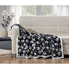 a living room with a couch covered in a skull and crossbones throw blanket