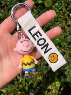 a hand holding a keychain with a cartoon character on it