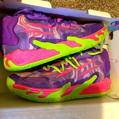 a pair of purple and green shoes in a shoe box