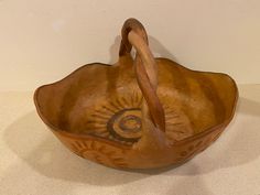 a wooden bowl with a handle that has an eye on it