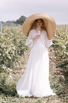 a woman in a white dress and straw hat