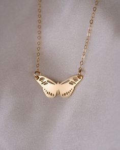 a gold necklace with a butterfly on it