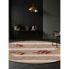 a round rug with red flowers on it in a room next to a chair and table