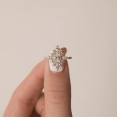 a woman's hand holding a diamond ring