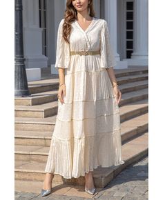 a woman standing on steps wearing a white dress