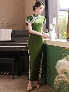 Fall in love with a long green qipao dress and its classy design. Made in a vibrant green color, this Chinese dress looks both elegant and refreshing. The satin fabric, carefully selected for its softness and comfort, adds a touch of sophistication to the long qipao dress. Fitted Green Maxi Dress For Banquet, Green Midi Dress For Banquet, Green Short Sleeve Evening Dress For Banquet, Fitted Green Midi Dress For Banquet, Fitted Dark Green Floor-length Dress, Dark Green Fitted Floor-length Dress, Green Midi Length Dress For Banquet, Green Spring Evening Dress For Banquet, Green Short Sleeve Dress For Wedding