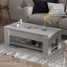 a grey coffee table sitting on top of a wooden floor next to a gray couch