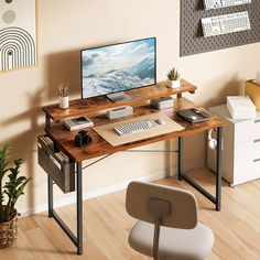 a computer desk with a monitor and keyboard on it in front of a wall mounted poster