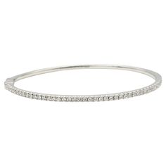 This gorgeous Tiffany & Co. diamond bangle bracelet is a stunning piece from the renowned Tiffany Metro Collection. This bangle exudes a streamlined, modern design reminiscent of a twinkling nighttime city skyline. It is the epitome of elegance, featuring exquisite natural diamonds that add a touch of brilliance to any ensemble. Crafted from 18-karat white gold, this hinged bangle showcases the finest craftsmanship and quality. The diamonds, with a total carat weight of 0.67 ctw, are cut in a ro Tiffany Bangle, Tiffany And Co Bracelet, Diamond Bangles Bracelet, Diamond Bangle, Tiffany And Co, Expensive Jewelry, Hinged Bangle, Tiffany & Co., Natural Diamonds