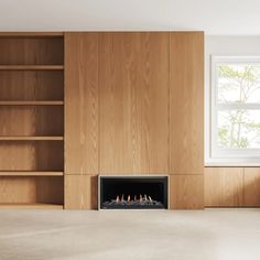 an empty room with a fire place in the center and bookshelves behind it