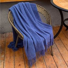 a blue blanket sitting on top of a wooden floor next to a chair and table